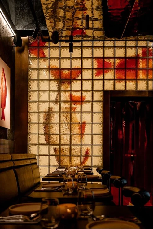A dining room with a gold koi wall